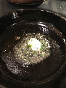 chive butter melting in cast iron pan