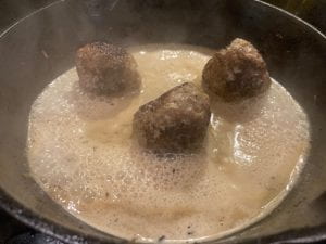 meatballs in skillet with cream sauce