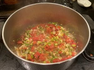 add tomatoes to other sautéed veggies