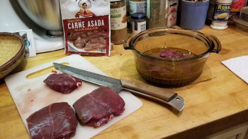 venison being cut and placed in marinade