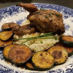 roasted quail on plate with mashed potatoes and zuchinni